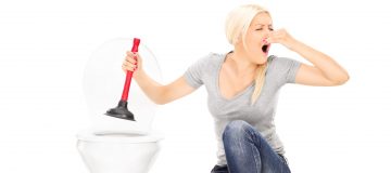 woman unclogging toilet - steatorrhea is a possible sign of pancreatic cancer
