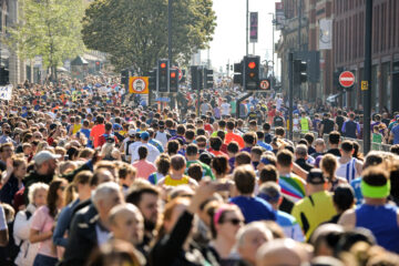 A sea of people, both runners, crowd. and general public, within a heavily urbanised area of Leeds, West Yorkshire